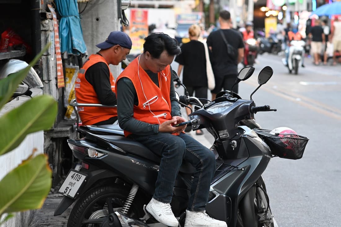 Delivery couriers between orders, checking their phones